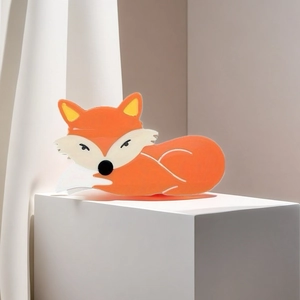 Vue détaillée d'une pince à cheveux renard orange en PVC sur un support géométrique épuré
