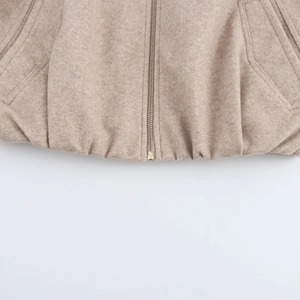 Detail of bomber jacket hem featuring zipper closure and textured wool fabric finish