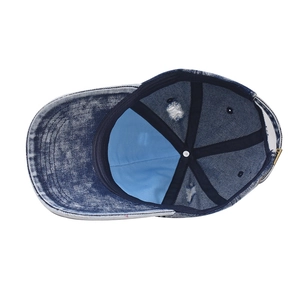 Macro detail of washed denim baseball cap with inner stitching and metal buckle