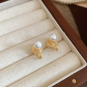 Detailed shot of pearl ear clips with gold finish and comfortable silicone pads