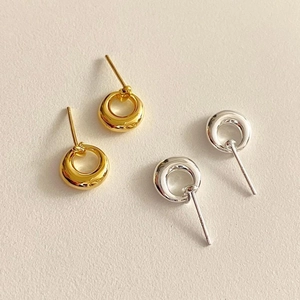 Detailed view of polished hollow round stud earrings in gold and silver finishes