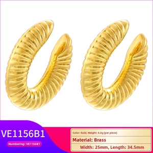 Macro shot of gold brass C-shaped heart ear clips with spiral texture and 25mm dimensions