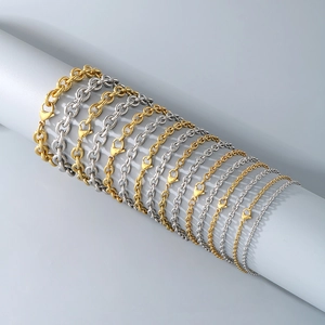 Chaînes en acier inoxydable or et argent exposées sur des supports cylindriques gris