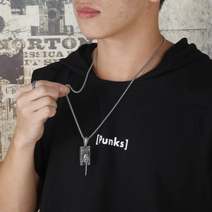Detail view of a vintage stainless steel tank pendant on a punk-style necklace for men