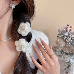 Gros plan sur d'élégantes barrettes fleur en tricot et bijoux en perles sur un modèle