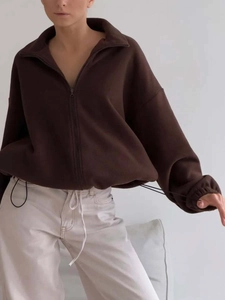 Close-up of brown fleece sports jacket featuring a full zipper and adjustable hem drawstring