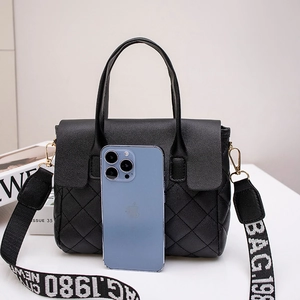 Black quilted leather handbag with wide jacquard strap and crossbody functionality
