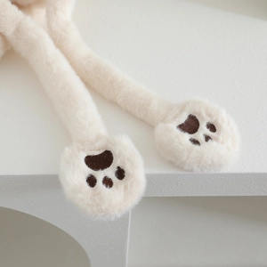 Detailed view of plush paw embroidery on creamy white faux fur earflap hat for kids