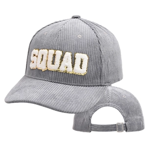 Close-up of SQUAD letter embroidery with gold sequins on grey corduroy baseball cap