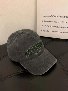Detailed embroidery of NEW YORK EST.1625 text on washed dark grey cotton baseball cap
