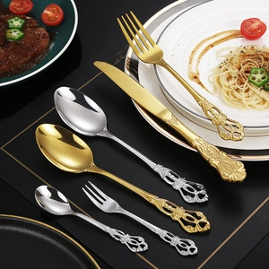 Detailed view of baroque style engraved stainless steel cutlery set with gold finish