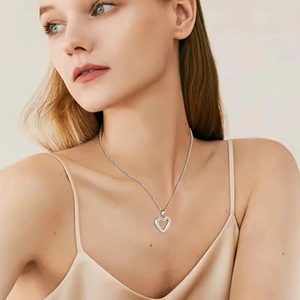 Silver stainless steel heart locket necklace for pet ashes worn by a female model