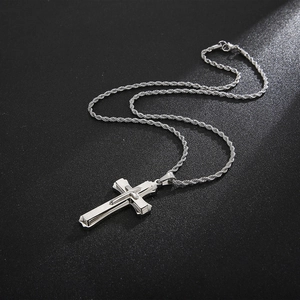 Macro detail of a silver stainless steel cross pendant with a classic rope chain