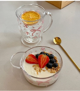 Détail de l'ensemble tasse et bol en verre avec motifs nœuds roses et fleurs fraîches
