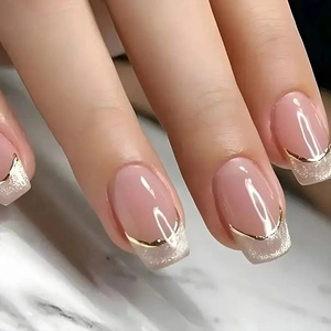 Detail of pink French press-on nails with golden lines and silver glitter tips on long square