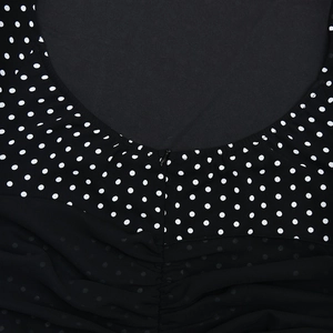 Detail of polka dot chiffon dress featuring a mesh pleated hem and hidden back zipper