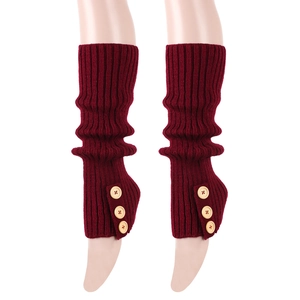Detail of burgundy ribbed knit leg warmers with vintage buttons on white background