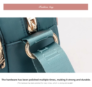 Detailed close-up of golden metal hardware and sturdy nylon strap on a crossbody bag