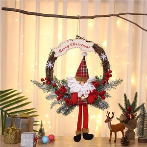 Christmas wreath with Santa doll and Merry Christmas banner on a vine ring base