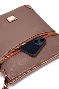 Close-up of brown pebbled leather crossbody bag showing front pocket holding a smartphone