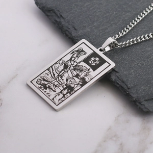 Detail of vintage Death tarot card pendant with intricate etching on stainless steel chain