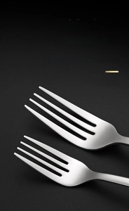 Macro shot of polished 304 stainless steel forks with smooth edges on textured background