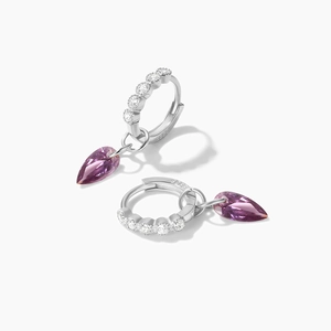 Macro shot of S925 sterling silver stamp and faceted purple pear-shaped gemstone earrings