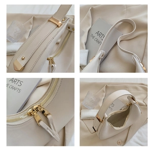 Close-up of crescent shoulder bag featuring cream leather and gold-tone hardware details