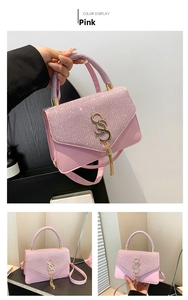 Detailed view of pink sequin handbag with gold S-logo hardware and leather strap