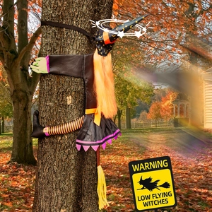 Detail of life-size crashing witch Halloween decoration with colorful fabrics on a tree trunk