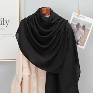 Classic black linen-cotton blend long shawl scarf with fringe on minimalist beige suit