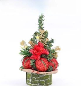 Close-up of a mini Christmas tree with pine needles, red glitter balls and golden heart accents