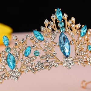 Close-up of gold bridal crown featuring blue marquise crystals and pavé diamonds