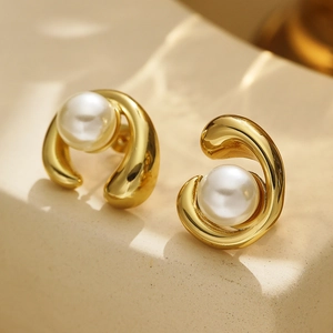 Detail of 18k gold earrings with irregular organic shapes and lustrous pearls