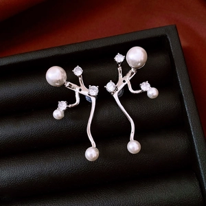 Close-up of vintage silver earrings with white pearls and zircons in a black leather box