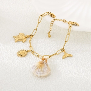 Détail du bracelet marin doré avec pendentifs tortue, soleil et coquillage violet