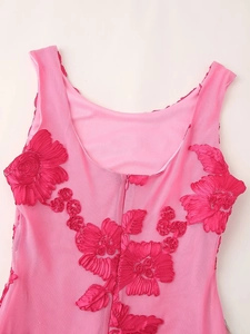 Detail of pink embroidered dress featuring ribbon flowers and back zipper closure