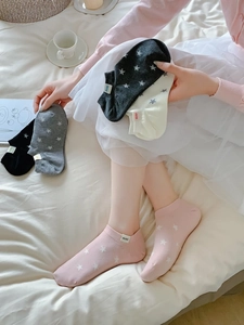Detailed view of knitted cotton low-cut socks with star patterns in five various colors