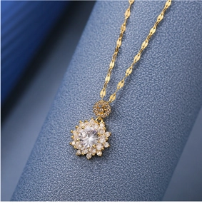 Macro shot of a gold sunflower necklace with zircon petals on a blue textured background