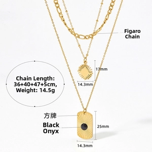 Detail view of layered gold Figaro necklaces with black onyx square and sunburst charms