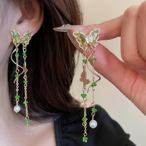 Long butterfly tassel earrings featuring green resin beads and white pearls in gold