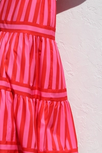 Detailed macro view of pink striped dress hem with tiered ruffle layers and soft fabric