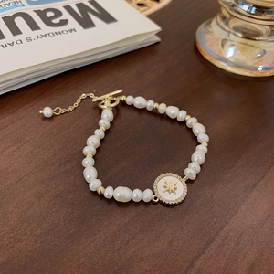 Detailed macro view of Baroque freshwater pearls and golden star pendant on wood