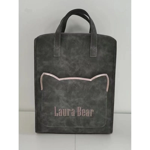 Detail of dark grey backpack featuring a cat ear shaped pocket and Laura Bear embroidery