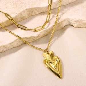 Double-layered 18K gold stainless steel necklace with 3D heart pendant on stone background