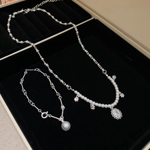 Detailed view of zircon pearl flower necklace and bracelet set in a jewelry box