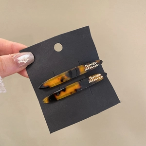 Close-up of tortoise shell barrette with Barrette La France text on a black card
