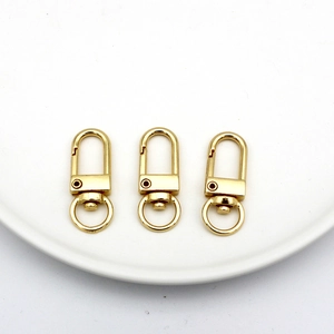 Detailed view of three golden metal D-ring spring lobster clasps for DIY jewelry making