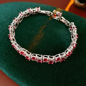 Makro-Detail eines zweilagigen Blumen-Verschlussarmband mit roten Zirkonia und Krappenfassung
