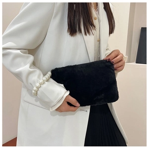 Detail of elegant black plush square handbag with pearl handle and stylish soft texture
